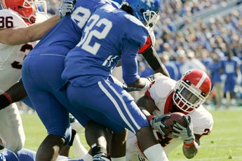 Georgia's Knowshon Moreno, right, dives past Kentucky players Trevard Lindley (32) and Christian Johnson for a touchdown Satirday.