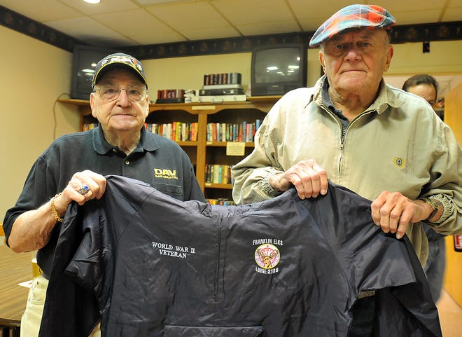 World War II veterans Frank DeRose (left) and George Lucas, hold a jacket created for their trip to Washington this weekend, Thursday in Franklin.