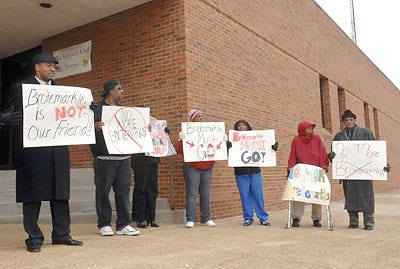 From left, Nathan Stephens, R. Jordan, Demetria Stephens, Arnita Jordan, Debbra Jordan, a woman who refused to give her name and pastor Ray Warren protest the on-duty status of Officer Mark Brotemarkle yesterday outside Columbia Police Department headquarters.