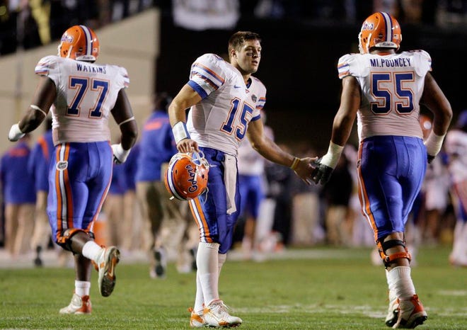 MARK HUMPHREY/Associated Press
Florida quarterback Tim Tebow (center) congratulates linemen Jason Watkins (left) and Mike Pouncey after a Gators touchdown during the 42-14 rout of Vanderbilt on Saturday night in Nashville, Tenn. His blockers helped Tebow complete 12-of-17 passes for 171 yards and three TDs.