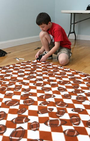 Holliston resident Tim Davidson, 9, spent his Veterans Day making blankets for children in an Appalachian community in Kentucky who have been using their coats as blankets.