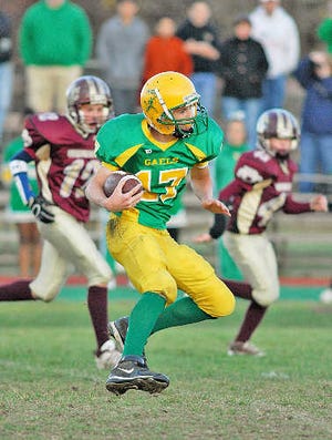 Clinton Jr. Midget quarterback Kyle Cutler runs with the ball during Sunday’s Central Mass. Super Bowl.