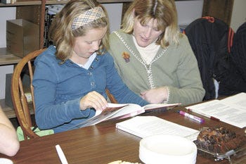 Taylor and Tracy Clark looked through an informational book about India, the country they had just visited via a fictional work.