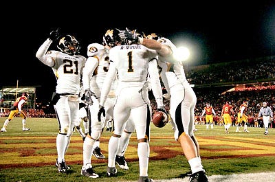Missouri players crowd around teammate William Moore (1) after the safety returned an interception for a touchdown in the first half of the No. 12 Tigers' 52-20 victory over Iowa State last night in Ames, Iowa. Combined with Kansas' loss to Texas earlier in the day, the win clinched the Big 12 North Division title for MU.