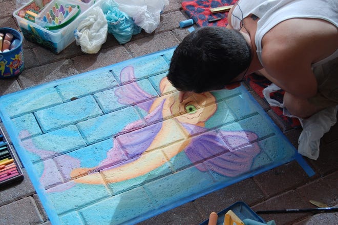 JASON YURGARTIS/SpecialJacob Brooks, 27, of Arlington, works feverishly on his chalk drawing of a koi fish. Brooks split first prize in the professional artist category at the Downtown Sidewalk Chalk Contest.