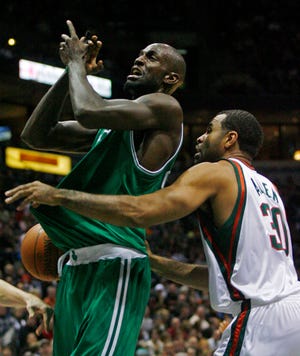Kevin Garnett of the Celtics, left, is fouled by the Bucks' Malik Allen during the first half of Saturday night's game in Milwaukee.