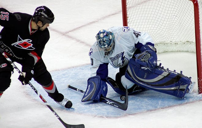 Tampa Bay Lightning goalie Mike Smith (41) covers the puck in front of 
Carolina Hurricanes' Tuomo Ruutu (15) during the first period in Raleigh, 
N.C., on Sunday. The Hurricanes defeated the Lightning 3-2 in a shootout.