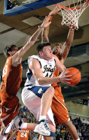 Notre Dame’s Luke Harangody drives between Texas’ Clint Chapman, left, and Gary Johnson during the first half of a Maui Invitational semifinal.