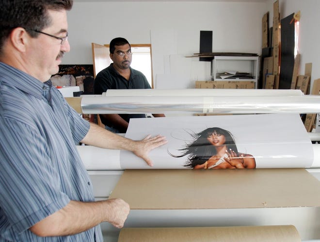 Fro Cruz, left, and Anand Ramchal begin laminating a photograph of model 
Naomi Campbell in Miami Beach earlier this month. The image, and about 50 
others of Campbell, will be shown starting Tuesday in Miami.