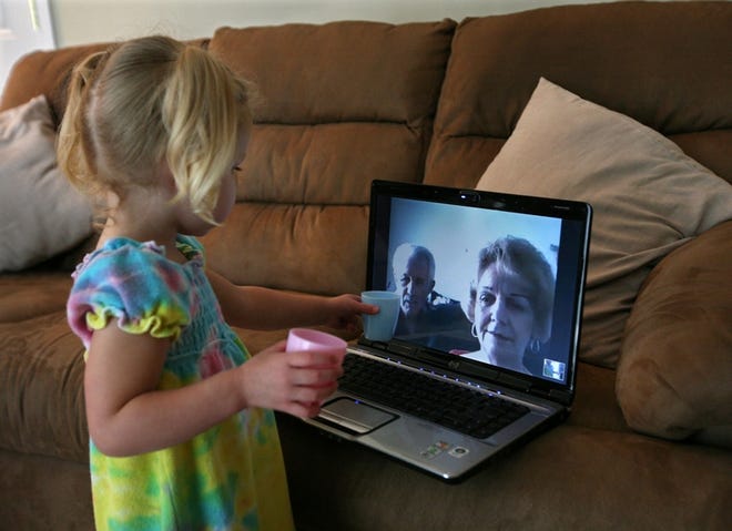 NEW YORK TIMES / JAMES ESTRINAME
Florida residents Elizabeth and Joseph Geosits, shown on the laptop screen, 
use computers and webcams to stay in touch with their granddaughter, 
Alexandra, who lives in Deer Park, N.Y.