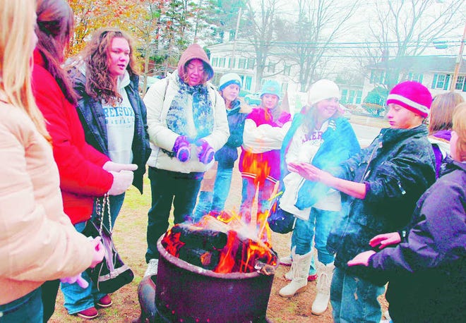 Area kids warm their hands over a fire on the common at last year’s White Christmas in West Brookfield.
