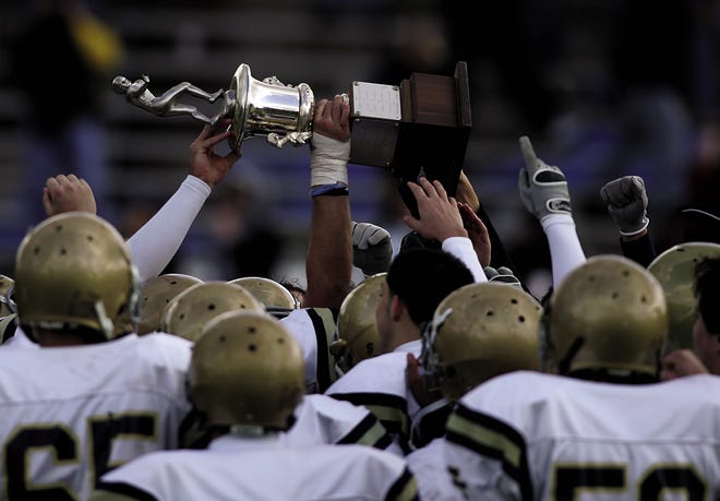 Members of the Coyle-Cassidy football team hoists the city championship trophy at Aleixo Tiger Stadium Thursday.