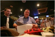 Over beers on Wednesday, Jim Burns, center, looked at a list of people who took the the buyout.
