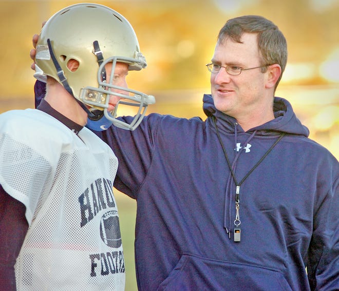 Hanover head coach Brian King chats with quarterback Matt Johnson at practice.