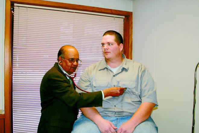 Dr. M. T. Ratnakar examines Michael Schafer, a patient of his since he was "a young boy." Ratnakar is retiring Dec. 31.