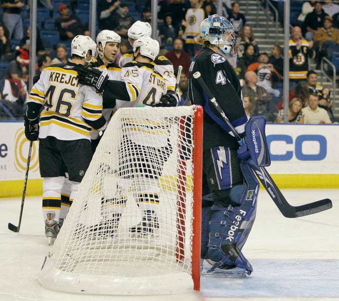 Lightning goalie Mike Smith (right) looks away as the Bruins celebrate David Krejci's goal last night.
