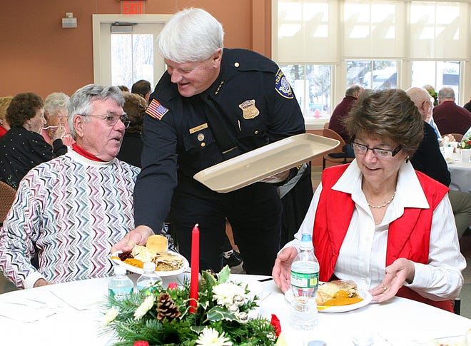 Franklin Police Chief Stephen Williams serves lunch to Don and Gail Lennon during the Franklin Police Association's annual turkey dinner for seniors, held a the Franklin Senior Center on Friday.