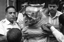 AP Photo
 A man with his face covered, identified by police as Mukhtar Ahmed, appears Saturday at a court in Calcutta, India. Ahmed allegedly bought phone cards from Tauseef Rahman who also was arrested in the Mumbai attacks.