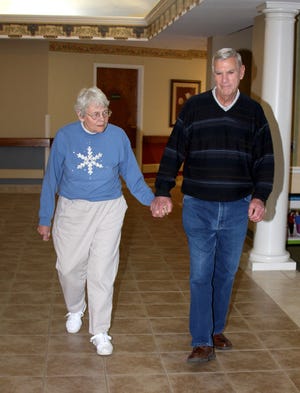 Lavere Kent holds his wife Joan’s hand as they walk the halls at Liberty Village in Freeport. Joan, who has Alzheimer’s disease, is a resident of Garden Court Special Care Unit.