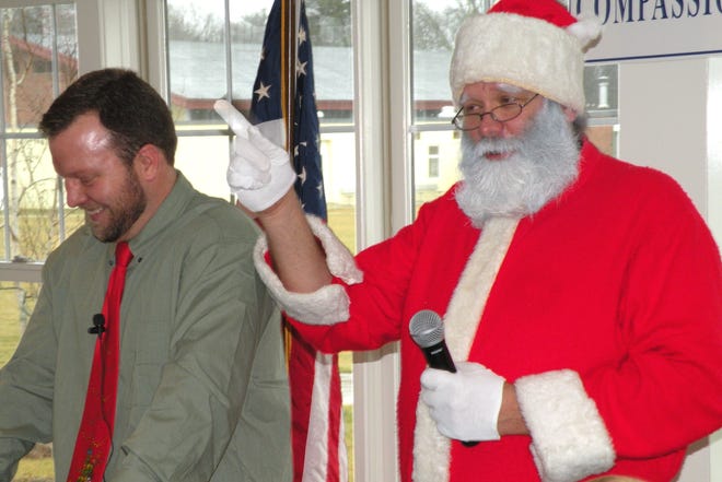 Santa, right, reminds everyone to be “good little boys and girls” for the holidays during the reading of “The Polar Express” by Hillside School teacher Brad Lofgren, left.