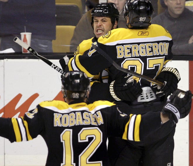 Boston's Marco Sturm is greeted by teammates Patrice Bergeron and Chuck Kobasew after scoring in the first period Thursday night.