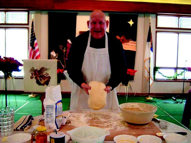 The Rev. G. Patrick White makes bread during his service at Christ Community Church of Allegan.