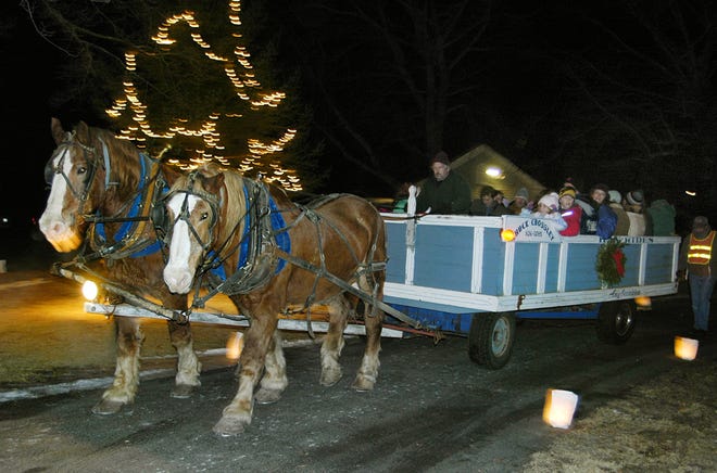 Jack, left, and brother Dick, Belgian draft horses owned by Chuck and Carolyn Crossley of Pembroke, pull the hay-ride wagon during the luminary festivities in Kingston in 2005. Jack was 22 when he died last week.