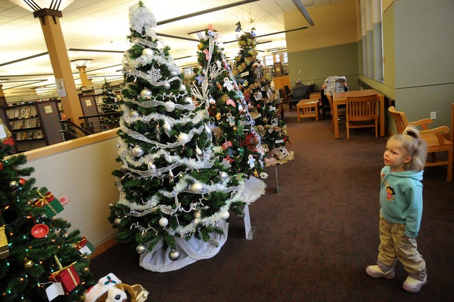 Emma May, 4, of Freeport looks at trees decorated by area groups on display at the Freeport Public Library on Saturday, Dec. 20, 2008.