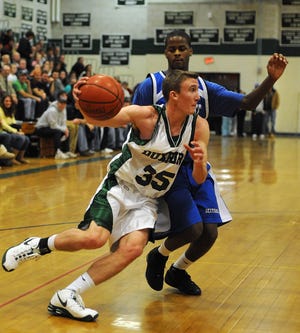 Duxbury’s Mark Brust drives to the basket against the Scituate defense during Monday night’s Patriot League game. Brust sank a free throw with three seconds remaining, sending the Green Dragons to a 61-60 triumph.