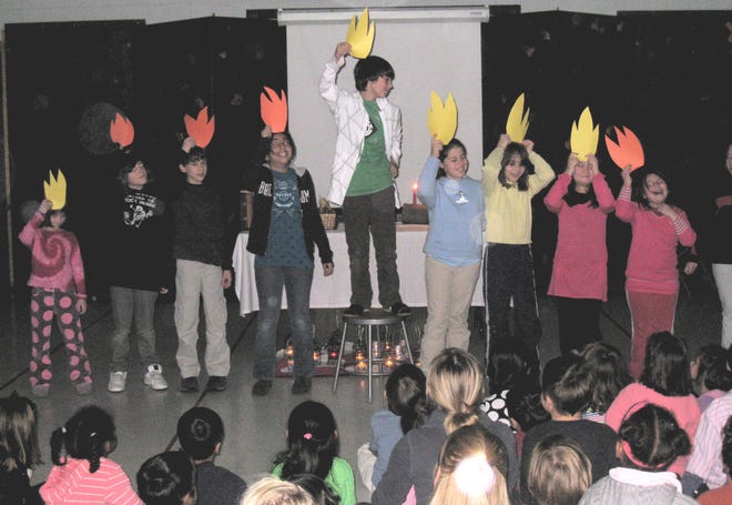 Students at Lexington Montessori School form a human menorah at their multicultural Festival of Lights celebration.