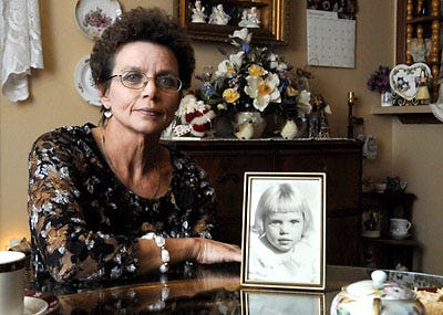 Sheila Bax poses with a photo of herself when she was 3. After the death of her adoptive parents, Bax is seeking her natural birth parents and siblings with the help of friends.