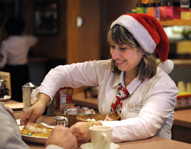 Saly Lowandy serves breakfast to a customer Christmas morning at Johnny Jack's Restaurant in Milford.