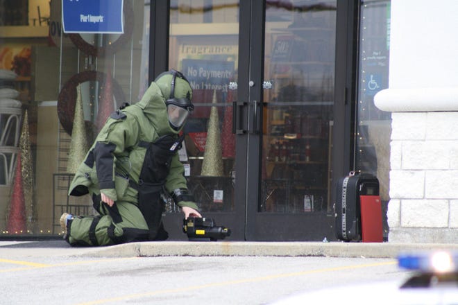 Trooper Scott Fahey of the Massachusetts State Police investigates report of a suspicious suitcase found at 1 p.m. Friday outside the front door of Pier 1 Imports on Granite Street. The store was evacuated and a perimeter was set up. X-rays determined there were no explosives inside.