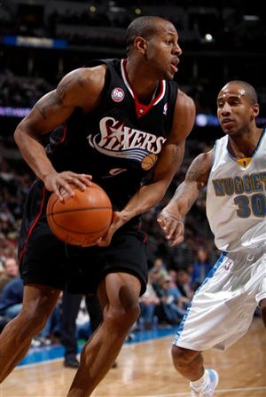 Philadelphia 76ers guard Andre Iguodala, front, drives the baseline for a shot past Denver Nuggets guard Dahntay Jones in the first quarter of an NBA basketball game in Denver on Friday, Dec. 26, 2008. (AP Photo/David Zalubowski)