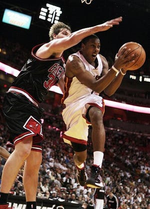 Miami Heat's Mario Chalmers, right, drives to the basket as Chicago Bulls' Aaron Gray defends during the fourth quarter of an NBA basketball game in Miami, Friday, Dec. 26, 2008. (AP Photo/Jeffrey M. Boan)