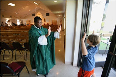 The Rev. Chrispin Oneko greeting a young parishioner in his Western Kentucky church.