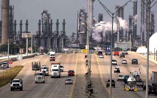 In this Nov. 21, 2007 file photo, Shell Oil Company's Deer Park refinery and petrochemical facility is shown in the background as vehicles travel along Highway 225 in Deer Park, Texas. A 50 percent increase in gasoline and diesel fuel taxes is being urged by a federal commissiion to finance highway construction and repair until a government devises another way for motorists to pay for using public roads.