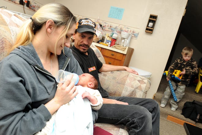 The first area baby of 2009, Rickey Alan Moore, relaxes with proud parents Heidi and Rickey Moore and stepbrother Bryce, 8, on Saturday, Jan. 3, 2009, at their home in Forreston.