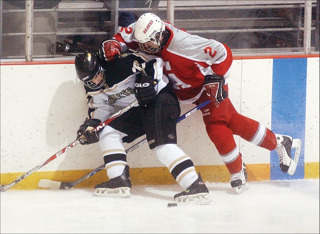 Canandaigua’s C.J. Roberts battles with Rush-Henrietta’s Jacob Clark along the boards for the puck in the first quarter of their Saturday game.
