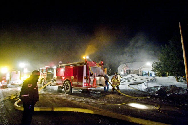 Firefighters work to put out a fire in a home at 6528 Stage Rd. in Marcy, Sunday, January 4, 2009.