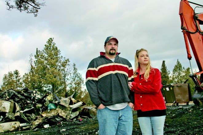 Rich and Timber Ortiz stand together where their home used to sit, before it was completely destroyed by fire on Dec. 20.