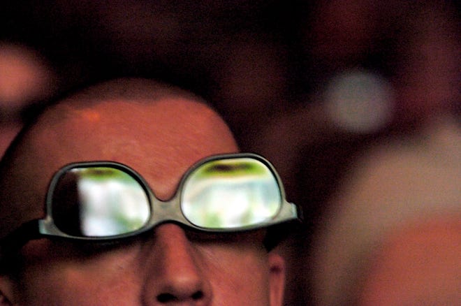 STAFF PHOTO / THOMAS BENDER / 
thomas.bender@heraldtribune.com
Brandon Abril, 26, of Largo looks through his 3-D glasses at the BCS 
championship game at the Royal Palm 20 theater in Bradenton on Thursday. He 
wore his glasses upside-down for better viewing.