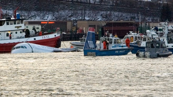 A US Airways plane is guided down the Hudson River Thursday in New York. The plane crashed into the frigid Hudson River on Thursday afternoon after striking a flock of birds that disabled two engines, sending 150 on board scrambling onto rescue boats, authorities say. No deaths or serious injuries were immediately reported.