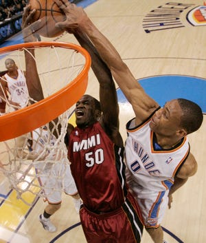 Oklahoma City Thunder guard Russell Westbrook, right, gets his hand on the 
ball to block a shot by Miami Heat center Joel Anthony, left, in the first 
quarter in Oklahoma City on Sunday.