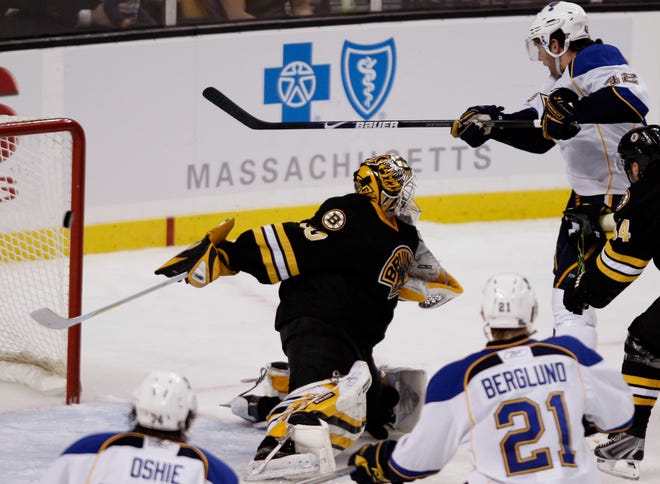 St. Louis’ David Backes, top, taps the puck past Bruins goalie Tim Thomas during the final second of the third period to tie the game.
