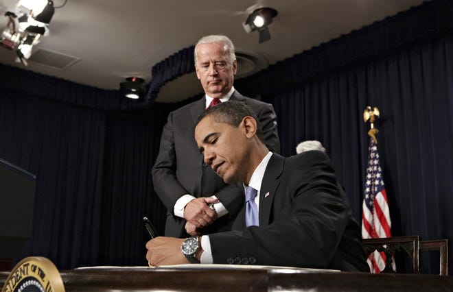 Vice President Joe Biden looks on as President Barack Obama signs executive orders during a meeting with their senior staff, Wednesday, Jan. 21, 2009, at the Eisenhower Executive Office Building on the White House campus in Washington. (AP Photo/J. Scott Applewhite)