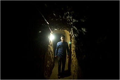 A Palestinian in a tunnel between Gaza and Egypt on Friday. It was under repair after being hit with Israeli bombs. The tunnels are used for smuggling.