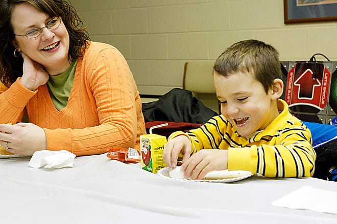 Melissa Murray of Adrian watches her son T.J., 5, eat his breakfast Saturday during the monthly Breakfast and Books event at the Lenawee County Library. In addition to eating breakfast and listening to stories, children also made winter crafts.