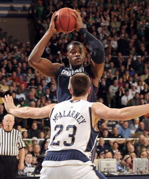 Connecticut forward Jeff Adrien pass around Notre Dame guard Kyle McAlarney during the first half of an NCAA college basketball game Saturday Jan. 24, 2009 in South Bend, Ind. (AP Photo/Joe Raymond)