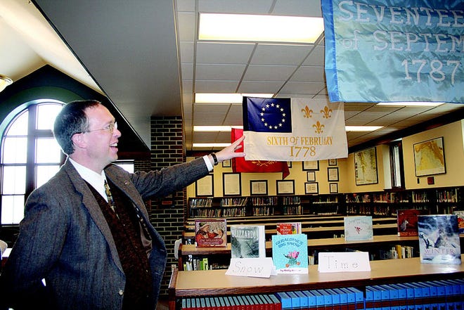 Hillsdale Academy Headmaster Kenneth Calvert, Ph.D., shows off the new flags in the school's library Monday, Jan. 26, 2009.
Each flag represents an important date in the American Revolution.